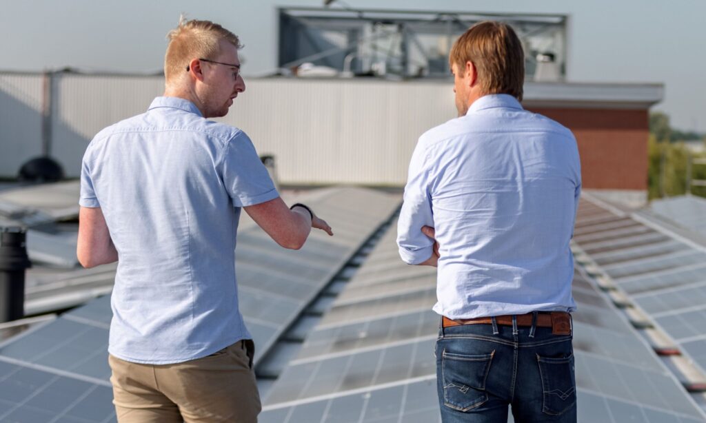 drie mannen op dak bij zonnepanelen